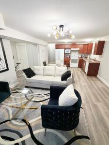 een woonkamer met een witte bank en stoelen bij True Haven Deluxe in Prince George