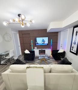 a living room with a white couch and a television at True Haven Deluxe in Prince George