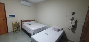 a room with two beds and a door at Studio Figueira, Sol in Santarém