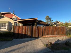 a wooden fence in front of a house at Casa Amayita in Puerto Varas
