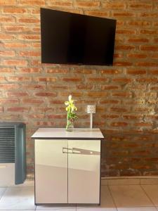 a white cabinet with a tv on a brick wall at Departamento Río Blanco - muy cerca del Lago Lezana in Cholila