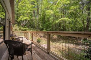 a porch with a chair and a fence at BEES KNEES A-frame Cabin for 2 hot tub wifi in Gatlinburg +89 photos