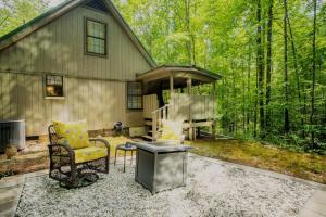 a house with a grill and a chair and a table at BEES KNEES A-frame Cabin for 2 hot tub wifi in Gatlinburg