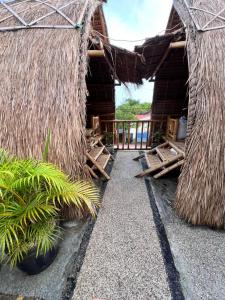 een vakantieoord met twee rieten hutten en een balkon bij The Twins Sunset Bungalow in Palebah