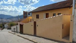 a yellow building with a gate in a street at Casa amarela - Perto do Centro in Poços de Caldas