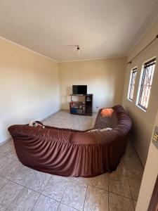 a large brown couch in a living room at Casa amarela - Perto do Centro in Poços de Caldas