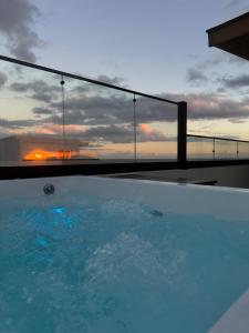 een zwembad met een zonsondergang op de achtergrond bij Boca Chica Luxury apartment in Boca Chica +29 foto's