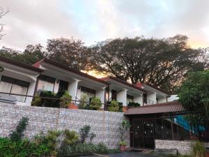 a house with a stone wall and a fence at Hotel Cielo Azul Resort in Tilarán