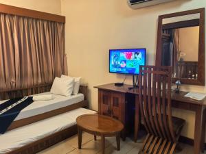 a hotel room with two beds and a desk with a television at Langkawi Lagoon Floating Resort 02 in Langkawi Intl