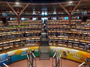 a large library with a staircase in the middle at Beans Stay Ishibiki in Kanazawa