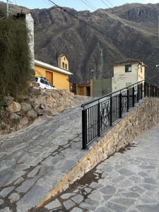 a fence on the side of a road with a mountain at Lavanda lodge Ollantaytambo in Ollantaytambo