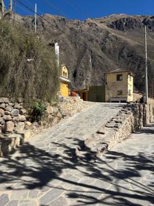 a road with a building on the side of a mountain at Lavanda lodge Ollantaytambo in Ollantaytambo +8 photos