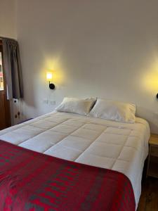 a bedroom with a large white bed with two pillows at Lavanda lodge Ollantaytambo in Ollantaytambo