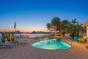 ein kleiner Pool auf einer Terrasse mit Stühlen und Wasser in der Unterkunft Luxury Waterfront Oasis in Port Richey