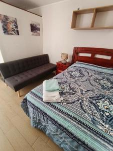 una camera da letto con un letto e un divano di Apartamento amoblado por Dia a Calama