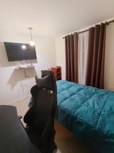 una camera da letto con un letto e una TV a schermo piatto di Apartamento amoblado por Dia a Calama