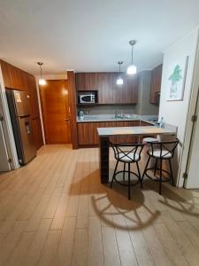 una cucina con 2 sgabelli da bar e piano di lavoro di Apartamento amoblado por Dia a Calama