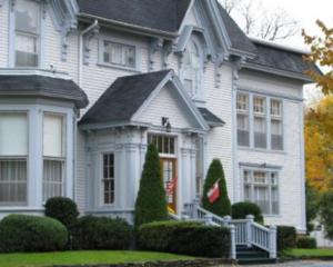 a white house with a flag in front of it at Shadow Lawn Inn in Rothesay