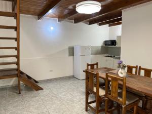 a kitchen with a wooden table and some chairs at Eucalipto Dúplex in San Vicente