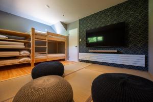 a living room with two chairs and a flat screen tv at COCO VILLA ニセコアンヌプリ-Niseko Annupuri in Rankoshi