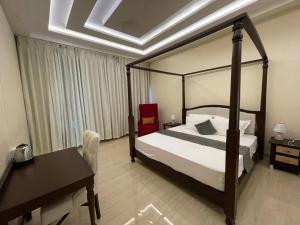 a bedroom with a bed and a table and a desk at Owls Oasis Kaziranga in Kāziranga