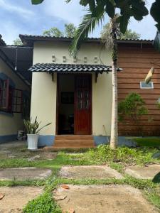 une maison avec un palmier devant dans l'établissement Bungalow Tina, à Duong Dong 1 autre photo