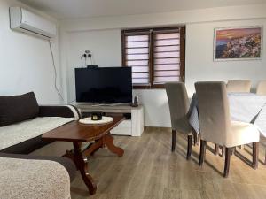 a living room with a couch and a table with a tv at Apartmani Fenix 29 in Ljubovija