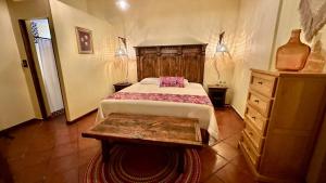 a bedroom with a bed and a wooden dresser at Casona Bartolome in Morelia