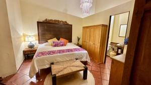 a bedroom with a large bed and a mirror at Casona Bartolome in Morelia