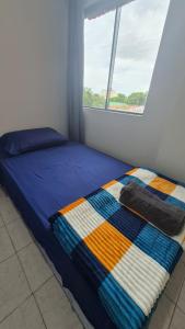 een bed met een kleurrijke deken in een slaapkamer bij Apartmento en Encarnación in Encarnación