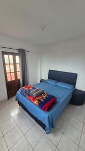 een slaapkamer met een bed met een blauwe deken erop bij Apartmento en Encarnación in Encarnación