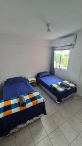 twee bedden in een kamer met een raam bij Apartmento en Encarnación in Encarnación