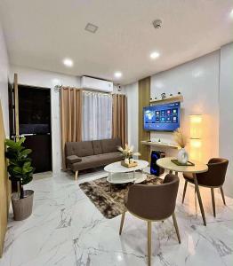 un salon avec un canapé et une télévision dans l'établissement 3Ks Transient House - Kyle Suite, à Romblon