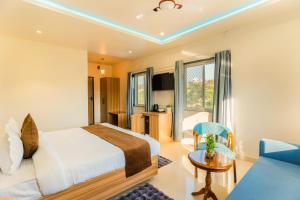 een hotelkamer met een bed en een bank bij The Oasis Retreat in Nāi