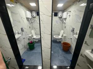 a bathroom with three toilets and two sinks and mirrors at Goldsport Dormitory in Jāmb