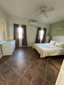 a bedroom with a white bed and a tile floor at The Palms apt 2 in Cedar Grove