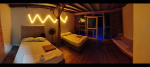 a small room with two beds and a window at Cabañas Palos Locos in Barú