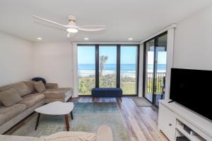 een woonkamer met een bank en een flatscreen-tv bij Sand Dollar 1-202 in St. Augustine