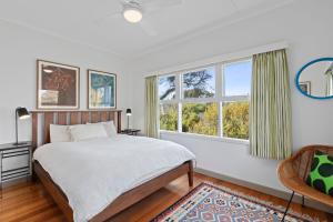 ein Schlafzimmer mit einem Bett und zwei Fenstern in der Unterkunft The Lonsdale House in Point Lonsdale