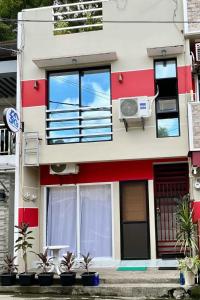 un bâtiment rouge et blanc avec des plantes devant dans l'établissement 3Ks Transient House - Kyle Suite, à Romblon 3 autres photos