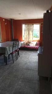 een kamer met een tafel, stoelen en een raam bij Cabañas Loley - a pasos del lago in Puerto Varas