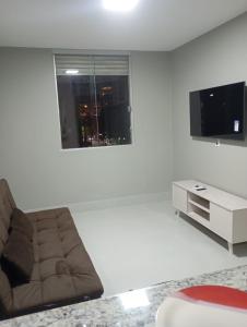 a living room with a couch and a flat screen tv at Conforto setor Oeste garagem 505 in Goiânia