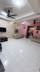 a large living room with a white tile floor at Zuma Homestay in Sungai Buluh