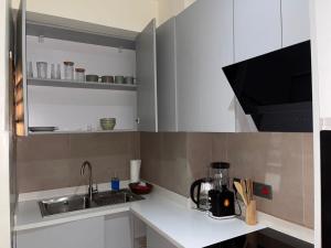 a kitchen with a sink and a counter top at The Veron, Dzorwulu in Lapaz