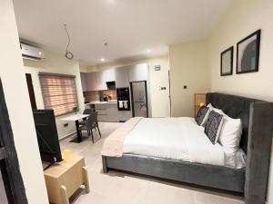 a bedroom with a large bed and a kitchen at The Veron, Dzorwulu in Lapaz