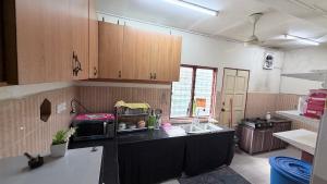a kitchen with a sink and a microwave at Zuma Homestay in Sungai Buluh +3 photos