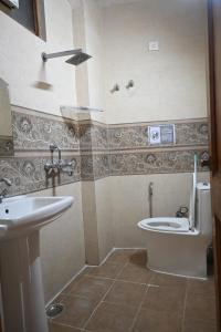 een badkamer met toilet en wastafel bij Hathayogashram Hostel in Rishīkesh +52 foto's