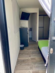 a small room with a bed and a blue door at Best View Aparta Hotel in Dosquebradas