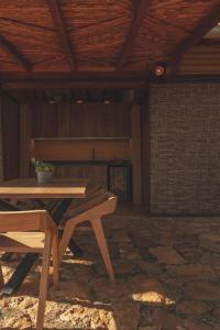 - une table et des chaises en bois dans une chambre avec plafond dans l'établissement Hotel Ambil, à Barichara