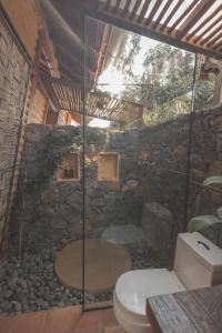 une salle de bain en pierre avec toilettes et un mur en pierre dans l'établissement Hotel Ambil, à Barichara 78 autres photos